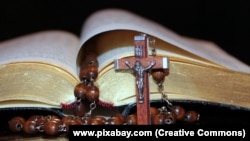 Библия, крест и четки. Иллюстрационное фото