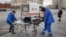 Ambulance workers transport an elderly woman -- with suspected coronavirus symptoms -- from a bus stop to a hospital in central Moscow on April 17.
