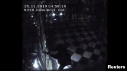 A biztonsági kamera felvétele alapján az egyik rabló épp betöri a drezdai királyi palota kincstárának egyik kirakatát 2019. november 25-én. 