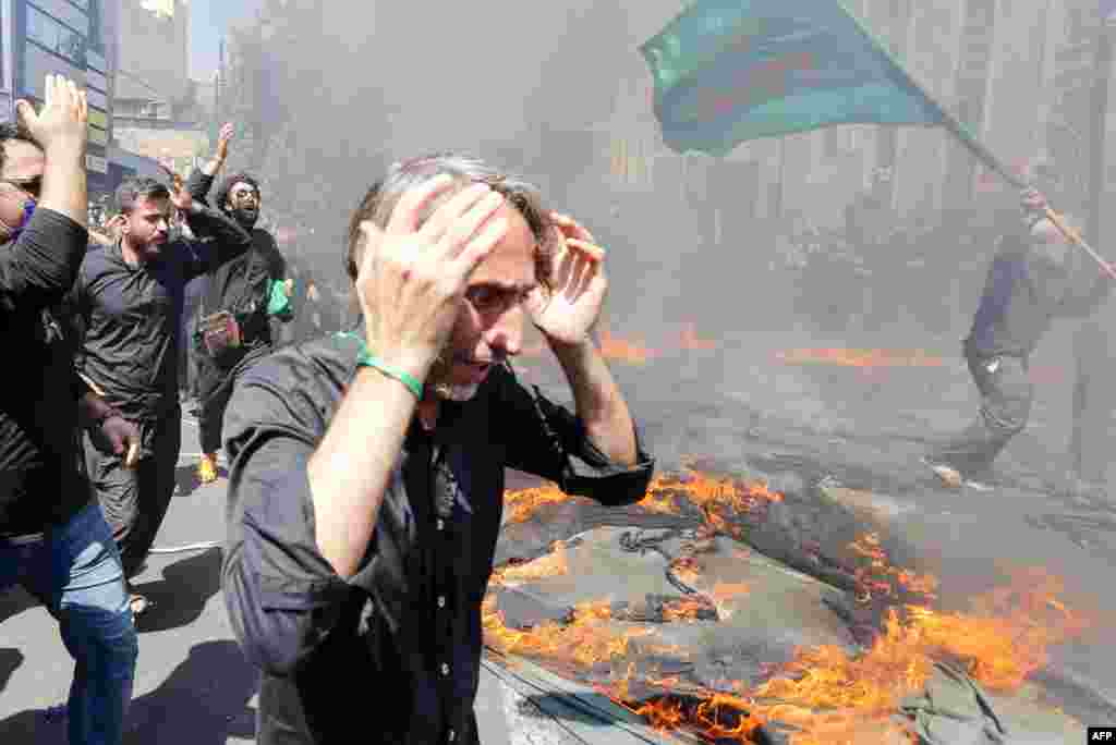 Iranian and Iraqi Shiite Muslims run past a burning tent during the reenactment of the events of the 10th day of the month of Muharram, which marks the peak of Ashura, in the Iranian capital of Tehran on August 30.