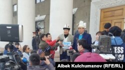 Аманбол Бабакулов (көп кагаздагы жазуу кармап турган жигит). 