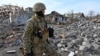 Український військовослужбовець дивиться на завали зруйнованих будинків на околиці Чугуєва Харківської області, 8 квітня 2022 року