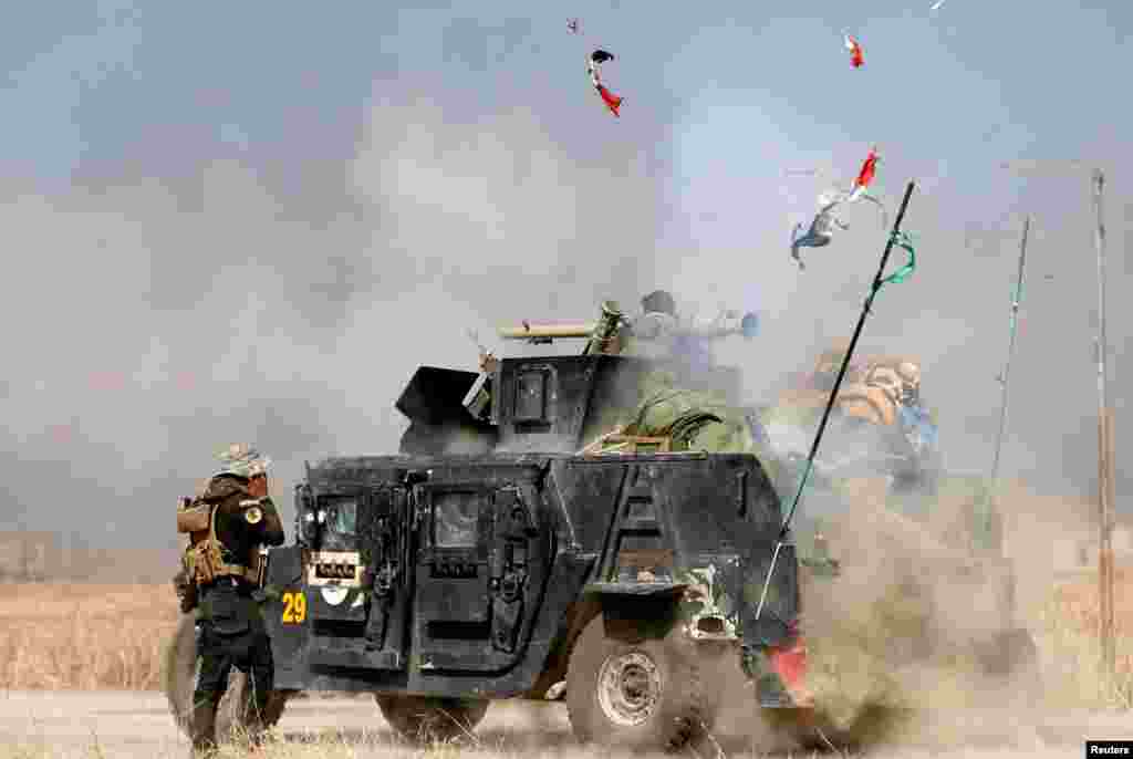 An Iraqi special forces soldier fires a cannon at Islamic States fighters in Bartella, east of Mosul, Iraq, on October 20. (Reuters/Goran Tomasevic)