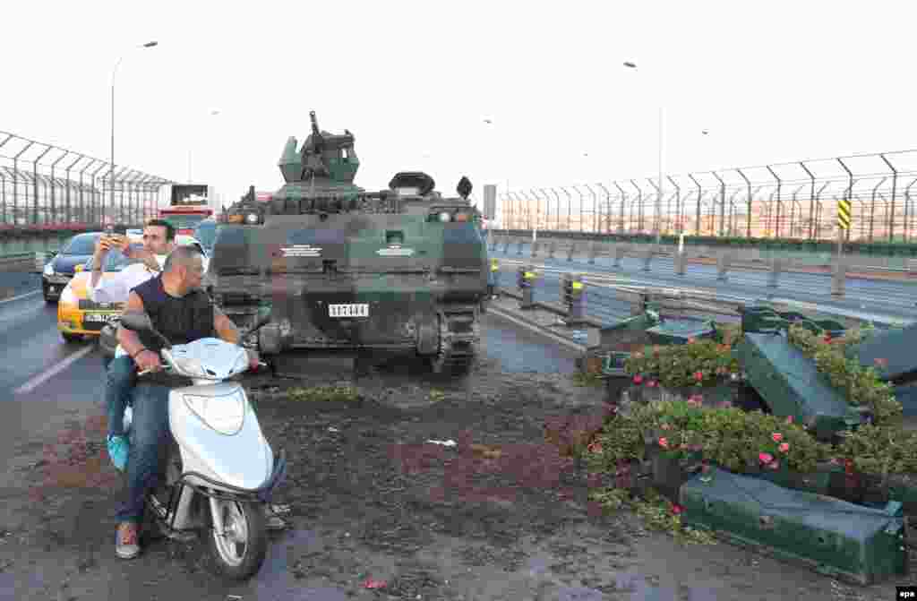 People take photographs of abandoned Turkish Army tanks on a road in Istanbul on July 16.