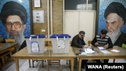 Poll workers are seen during parliamentary elections at a polling station in Tehran, February 21, 2020