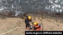 Спасатели поднимают мужчину, который сорвался в море