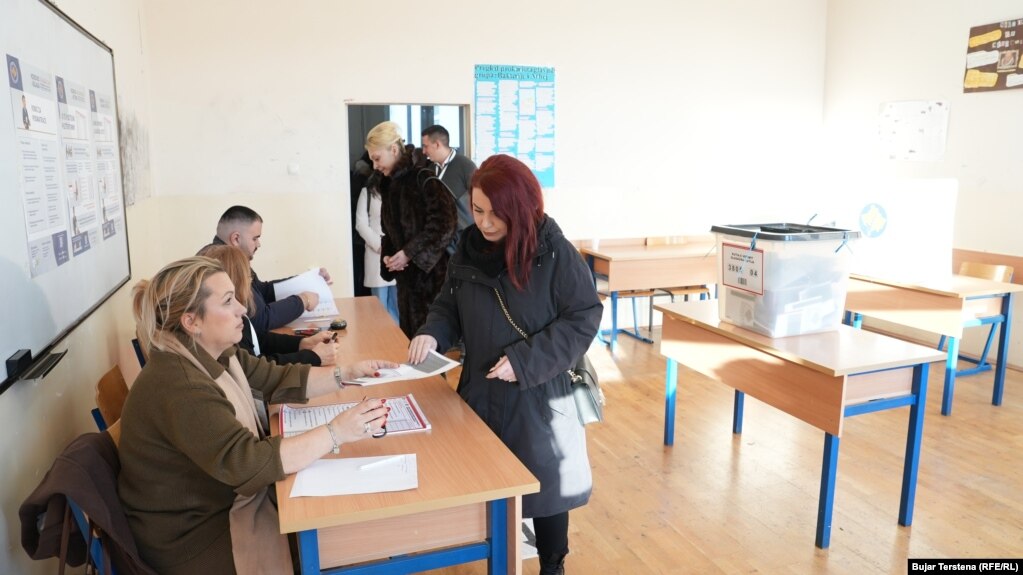 Një grua në veriun e banuar me shumicë serbe në Kosovë regjistrohet dhe merr fletëvotimin për të votuar në zgjedhjet e parakohshme parlamentare të Kosovës.