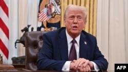 U.S. President Donald Trump speaks to the media in the Oval Office of the White House on January 23.