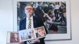 Stephen Capus poses with the photos of RFE/RL imprisoned journalists (L-R) Russia' Nika Novak, Belarus' Ihar Losik and Azerbaijan's Farid Mehralizada