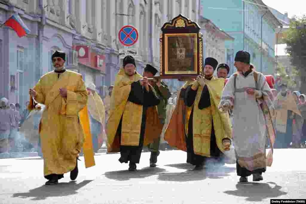 Orthodox clergymen carry the venerated icon of St. Nicholas.