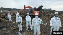Паліцыянты ў ахоўным адзеньні ўшаноўваюць памяць ахвяраў у прэфэктуры Фукусіма