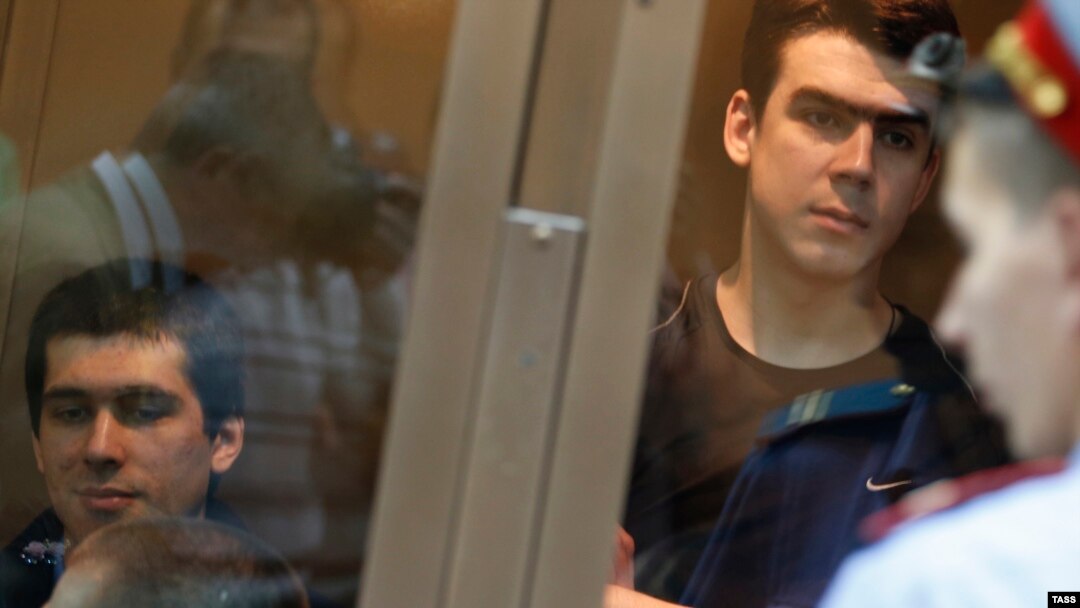 Defendants facing trial over clashes with the police during the Bolotnaya protests stand inside a glass-walled cage before a court hearing in Moscow earlier this year.