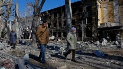 Oamenii trec pe lângă un spital de copii avariat în urma bombardamentelor din orașul Donețk, controlat de Rusia, din Ucraina, la 9 martie