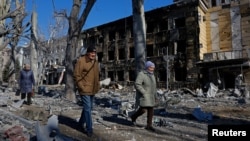 People walk past a children's hospital that was damaged by shelling in the Russian-controlled city of Donetsk, Ukraine, on March 9.