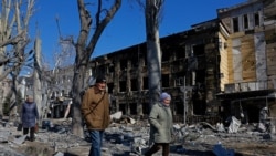 Люди проходять повз пошкоджену обстрілами дитячу лікарню в окупованому Росією Донецьку, 9 березня 2026 року