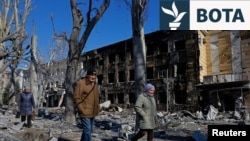 Njerëzit ecin pranë një spitali për fëmijë që u dëmtua nga bombardimet në qytetin e Donjeckut, Ukrainë, të kontrolluar nga Rusia, më 9 mars.