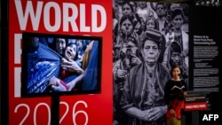 Joumana El Zein Khoury, directoarea executivă a World Press Photo, anunță câștigătoarea premiului „World Press Photo of the Year 2026”, fotografa din SUA Carol Guzy (fotografia câștigătoare este prezentată în stânga), la Amsterdam, pe 23 aprilie 2026.