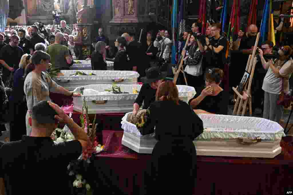 Mourners gather around the coffins of a mother and her three daughters who all died in a Russian missile strike in Lviv on September 4. Only the father survived.