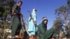 Taliban fighters stand on a vehicle along the roadside in Herat on August 13.