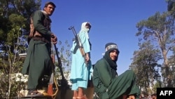 Taliban fighters stand on a vehicle along the roadside in Herat on August 13.