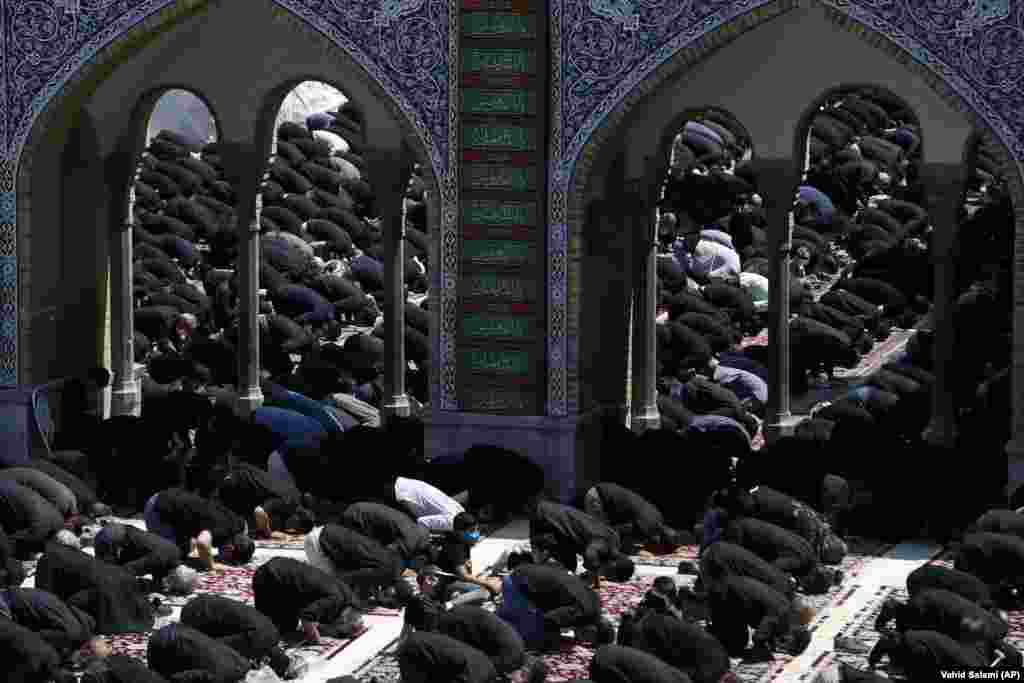 People attend the noon prayer for Ashura on August 30 in the courtyard of the St. Abdulazim shrine, in Shahr-e Ray, south of Tehran.