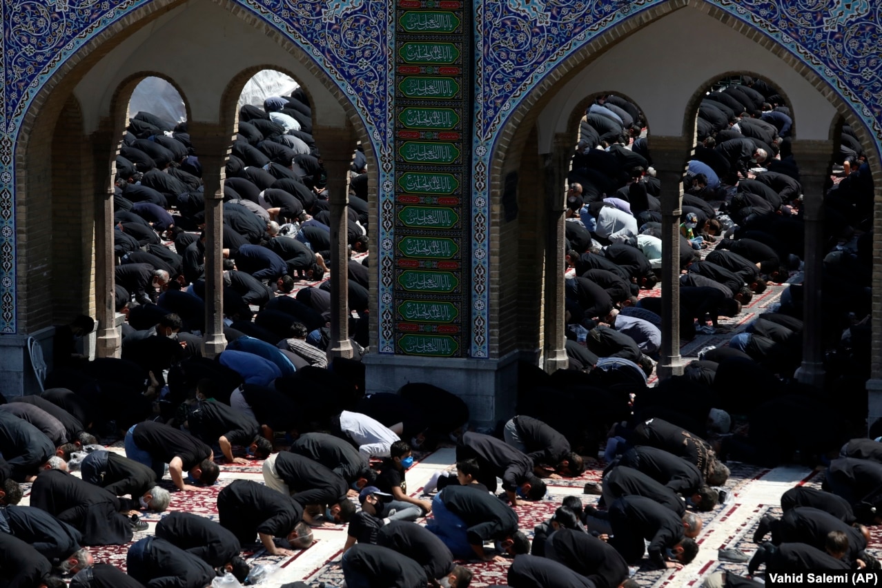 People attend the noon prayer for Ashura on August 30 in the courtyard of the St. Abdulazim shrine, in Shahr-e Ray, south of Tehran.