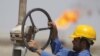 A worker adjusts a pipe at the Nassiriyah oil field, southeast of Baghdad.