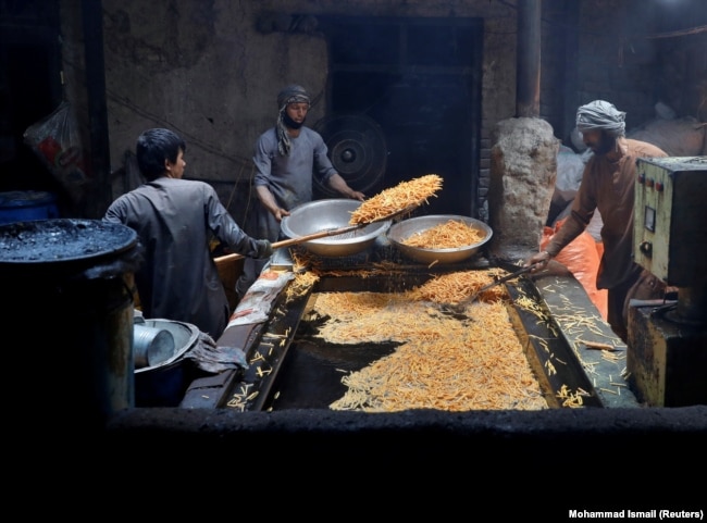 Men cook potatoes at a small traditional factory in preparation for Eid al-Fitr in Kabul on May 21.