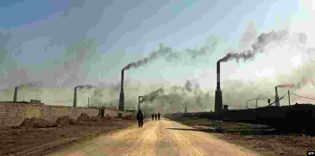 Punëtorët ecin në një nga fabrikat më të mëdha të tullave në Irak, të vendosura në rrethinat lindore të kryeqytetit, Bagdad.