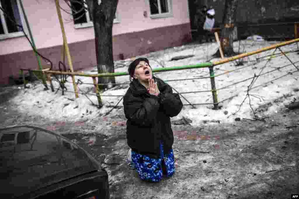 A Ukrainian woman prays for President Petro Poroshenko to stop the bombing in Donetsk after a shell hit the residential area where she lives, killing two civilians in the city&#39;s Kyibishevsky district on January 29. (AFP/Manu Brabo)