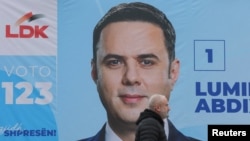 Një person kalon pranë një bilbordi me fotografinë e kreut të LDK-së, Lumir Abdixhiku, në Prishtinë më 21 dhjetor 2025. 