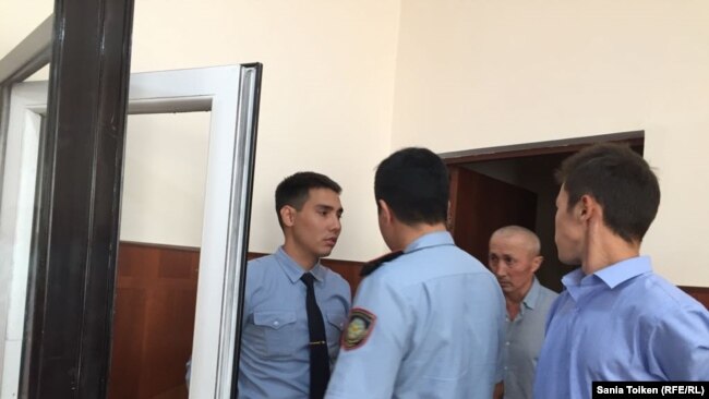 Полицейские заводят Абловаса Джумаева в зал суда. Актау, 12 сентября 2018 года.