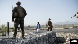 Czech soldiers walk toward a suspension bridge over a river during a patrol near Bagram Airfield in Parwan province Afghanistan.