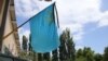 Крымскотатарский национальный флаг с траурной лентой. Иллюстрационное фото