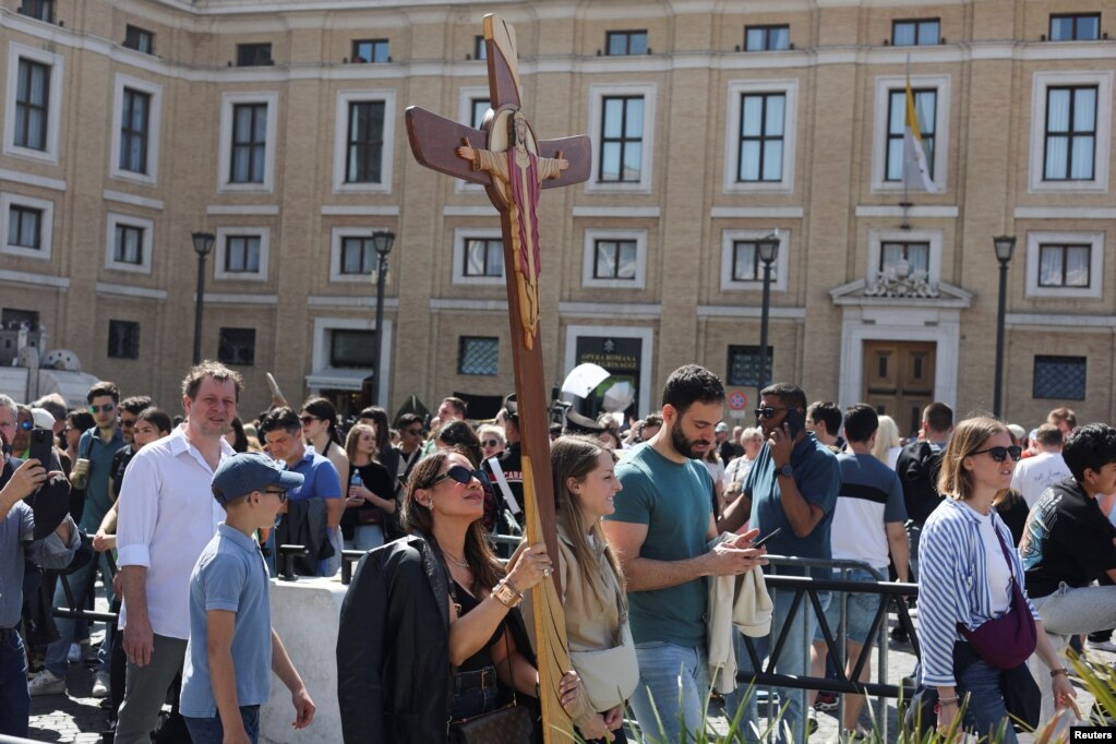 Një grua mban një kryq në Sheshin e Shën Pjetrit në Vatikan, pas vdekjes së Papa Françeskut, në Romë, Itali.
