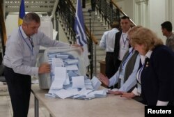 Membri ai unei comisii electorale varsă o urnă de vot după închiderea secțiilor de votare la alegerile parlamentare din Republica Moldova, la Chișinău, 28 septembrie 2025.