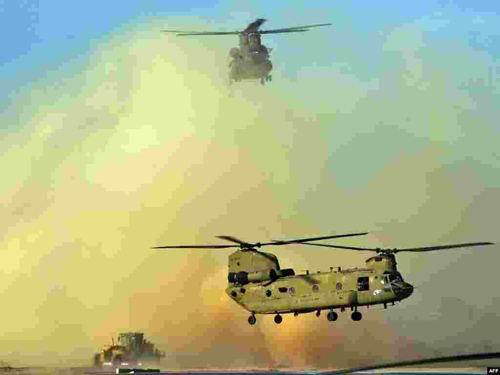 Two U.S. Army Chinook helicopters land at Kandahar airfield in southern Afghanistan on March 30. Photo by Peter Parks for AFP