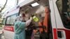 Медичний працівник у захисному костюмі дезінфікує машину швидкої допомоги після виїзду. Олександрівська міська клінічна лікарня, Київ, 9 квітня 2020 року