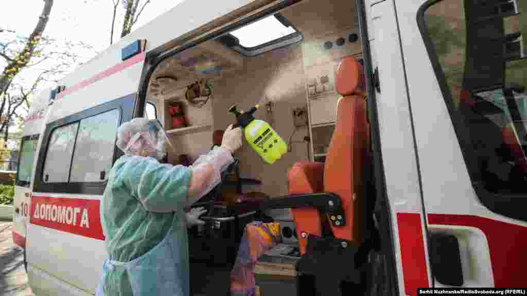 Медичний працівник у захисному костюмі дезінфікує машину швидкої допомоги після виїзду. Олександрівська міська клінічна лікарня, Київ, 9 квітня 2020 року
