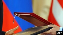 Czech Republic -- US President Barack Obama and his Russian counterpart Dmitry Medvedev exchange the signed new START Treaty documents at Prague Castle, 08Apr2010