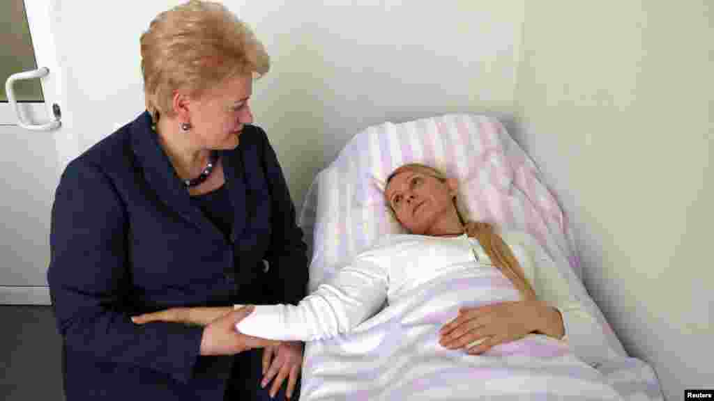 Lithuanian President Dalia Grybauskaite (left) holds the hand of jailed Yulia Tymoshenko during a visit to the Kharkiv hospital where Tymoshenko was being treated in May 2012.