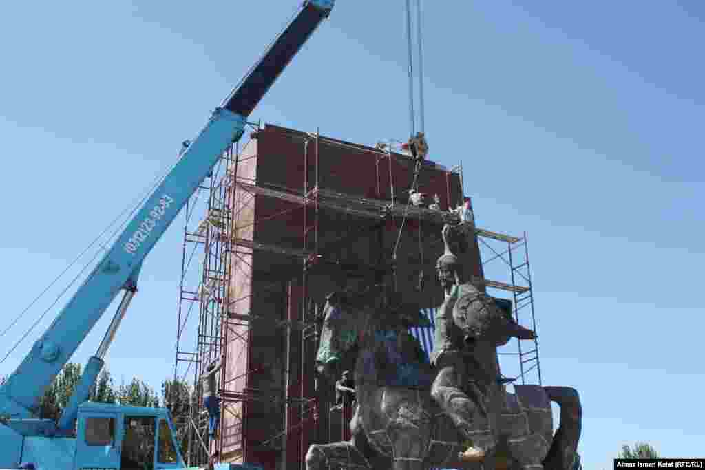 Автор монумента скульптор Базарбай Сыдыков. Манас сидит на коне, в левой руке у него щит, правая рука поднята для приветствия, у него есть меч, но он в ножнах.