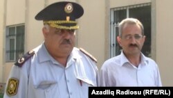 Editor Hilal Mamedov (right) of the Talysh-language independent newspaper "Tolishi Sada" is escorted by police in Baku on June 22.