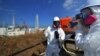 A journalist checks the radiation level with her dosimeter before the stricken Fukushima Daiichi nuclear power plant in Fukushima Prefecture on February 28.