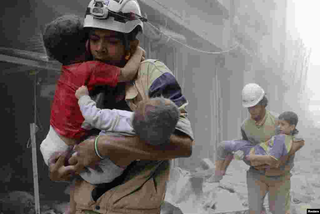 Members of the Civil Defense rescue children after what activists said was an air strike by government forces in Al-Shaar neighborhood of Aleppo, Syria, on June 2. (Reuters/Sultan Kitaz)