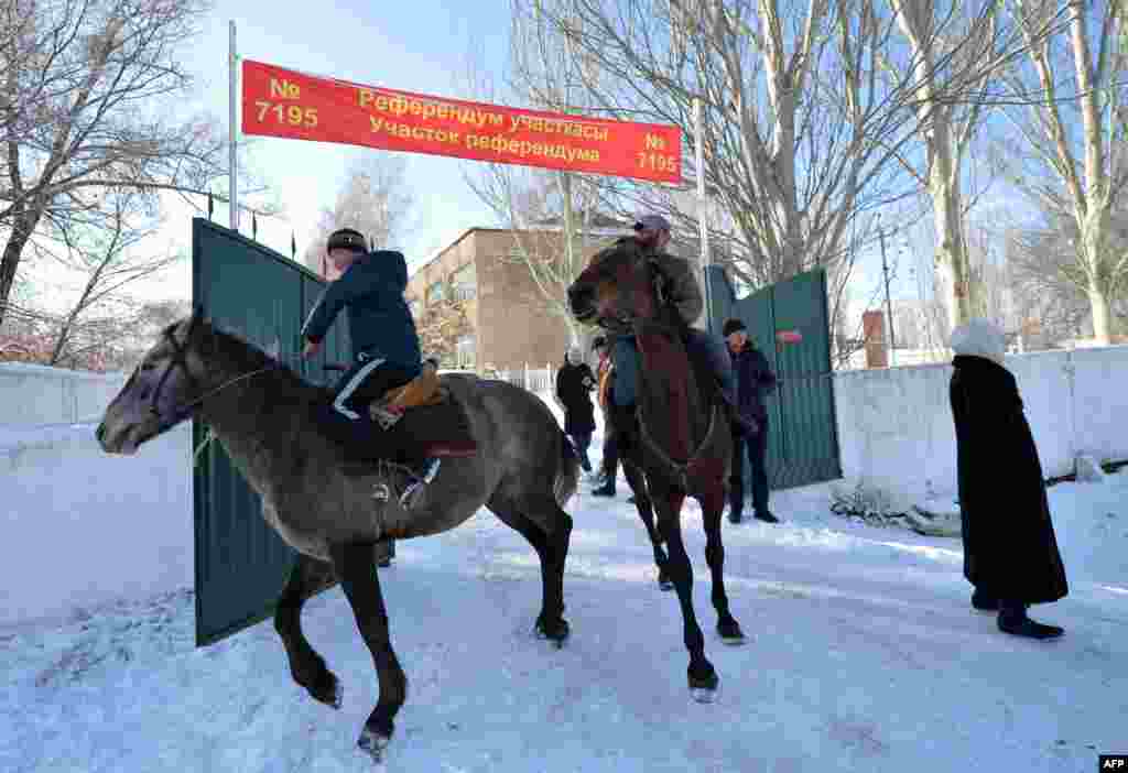 Kyrgyz men arrive on their horses to a polling station during a constitutional referendum in Bishkek. (AFP/Vyacheslav Oseledko)