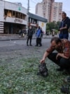 Un bărbat inspectează o bucată de motor după atacurile rusești cu drone de la Kiev, din noaptea de 20 spre 21 iulie. În fundal se vede o intrare în stația de metrou Lukianivska.