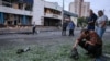 Un bărbat inspectează o bucată de motor după atacurile rusești cu drone de la Kiev, din noaptea de 20 spre 21 iulie. În fundal se vede o intrare în stația de metrou Lukianivska.