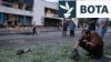 Një burrë inspekton një pjesë motori pas sulmeve ajrore ruse me dronë gjatë natës në Kiev, më 20-21 korrik. Në sfond shihet hyrja e stacionit të metrosë Lukyanivska.