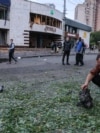 A man inspects a piece of engine after a night of Russian drone strikes in Kyiv on July 20-21. In the background is an entrance to the Lukyanivska subway station.